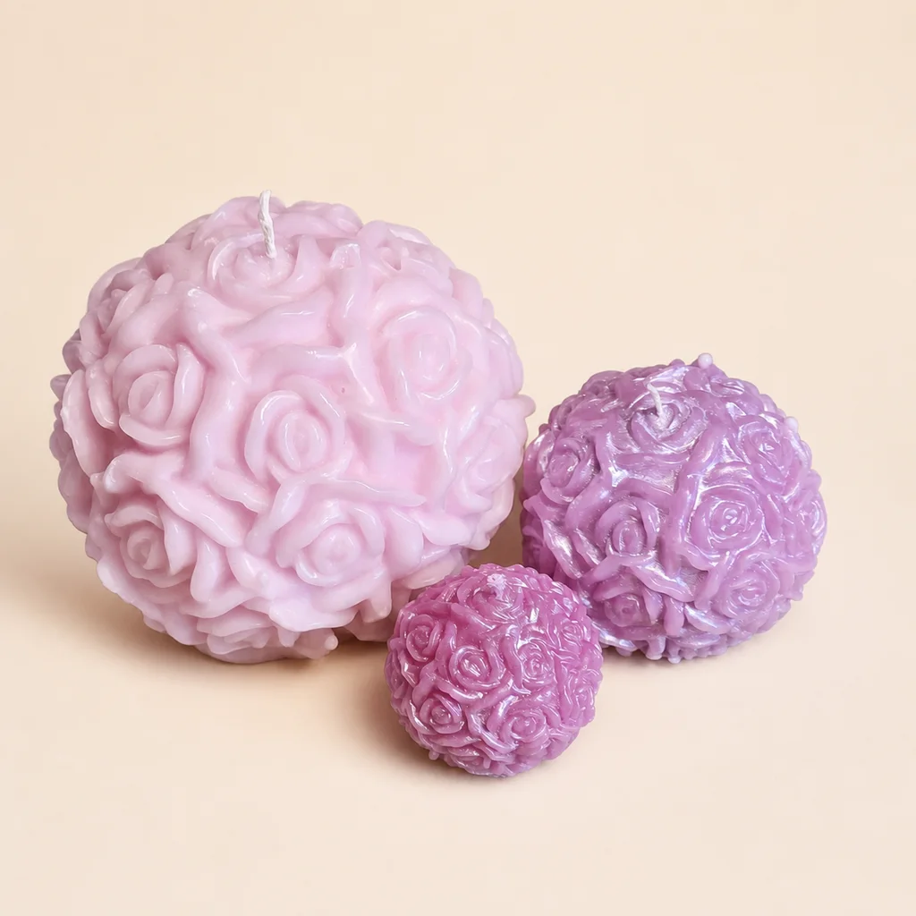 Tre rosformade dekorationsobjekt i rosa och lila